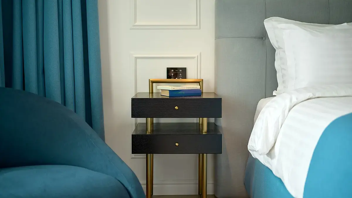 Bedside table with books in a hotel room.