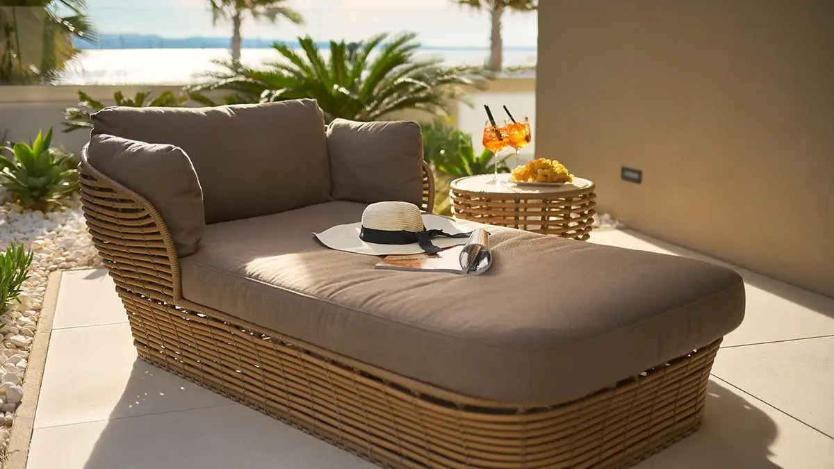 Garden furniture with grapes, cocktails, and a magazine in a hotel room overlooking the marina and sea.