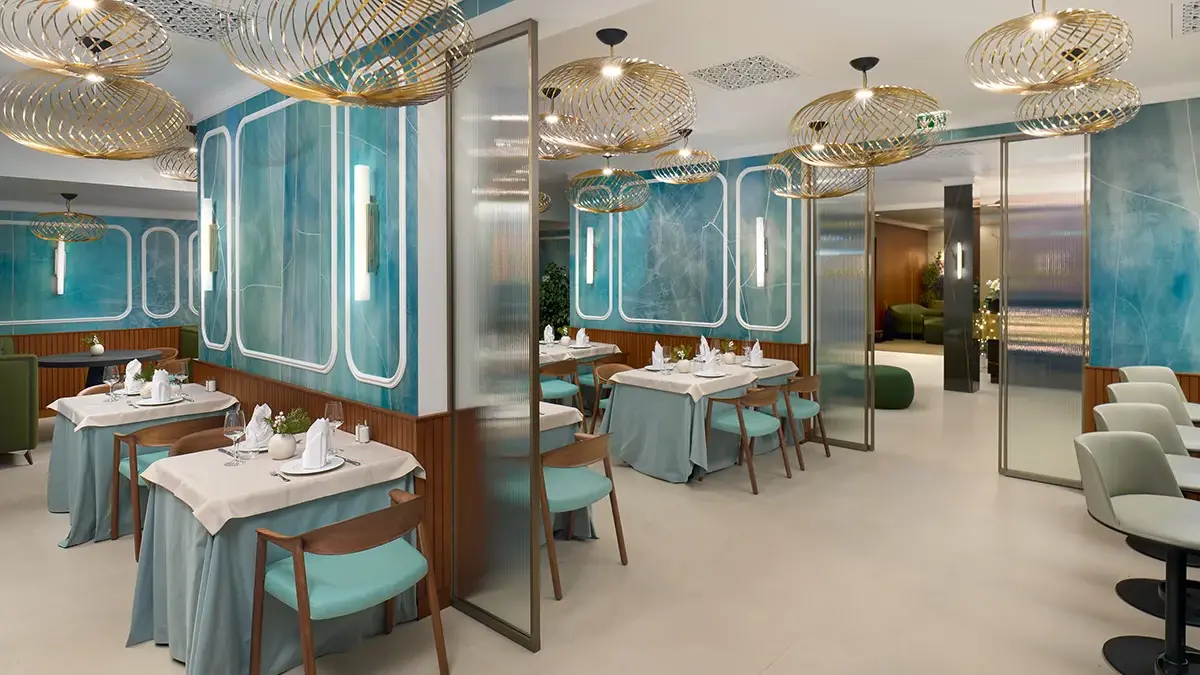 Interior of restaurant Mirari, with blue walls, golden lamps and dark wooden chairs