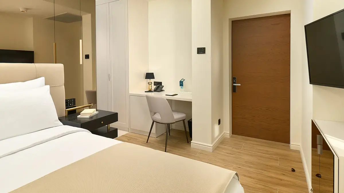 King sized bed in Boutique Hotel Mirari room with chair and table